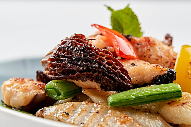 精美瓷盤裝的黑胡椒彩椒蜜豆山藥小炒羊肚菌