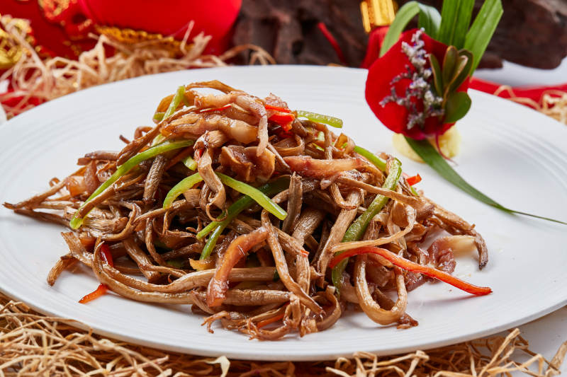 白色瓷盘装的茶树菇小炒肉丝