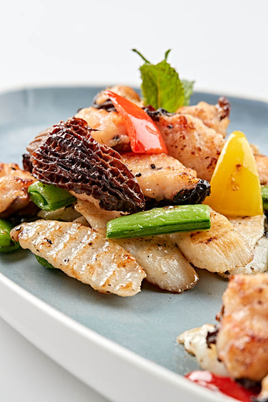 精美瓷盤裝的黑胡椒彩椒蜜豆山藥小炒羊肚菌