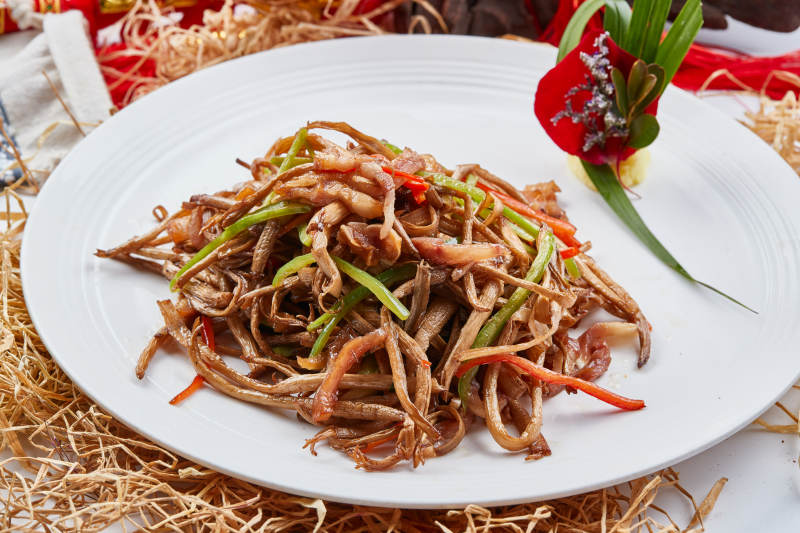 白色瓷盘装的茶树菇小炒肉丝