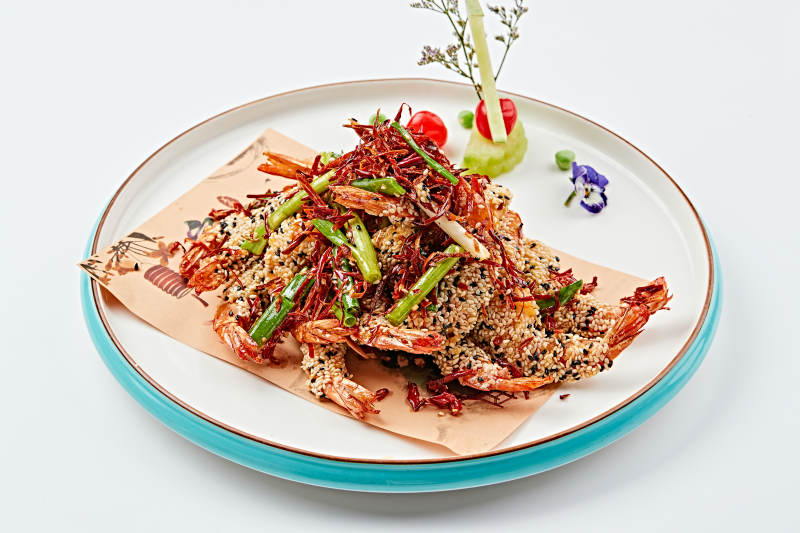 白色瓷盘装的油炸椒盐芝麻深海虾