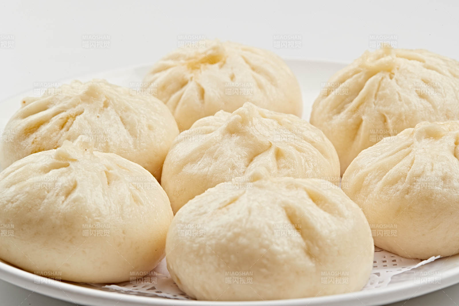 白色瓷盤裝的熏肉餡料傳統大包子