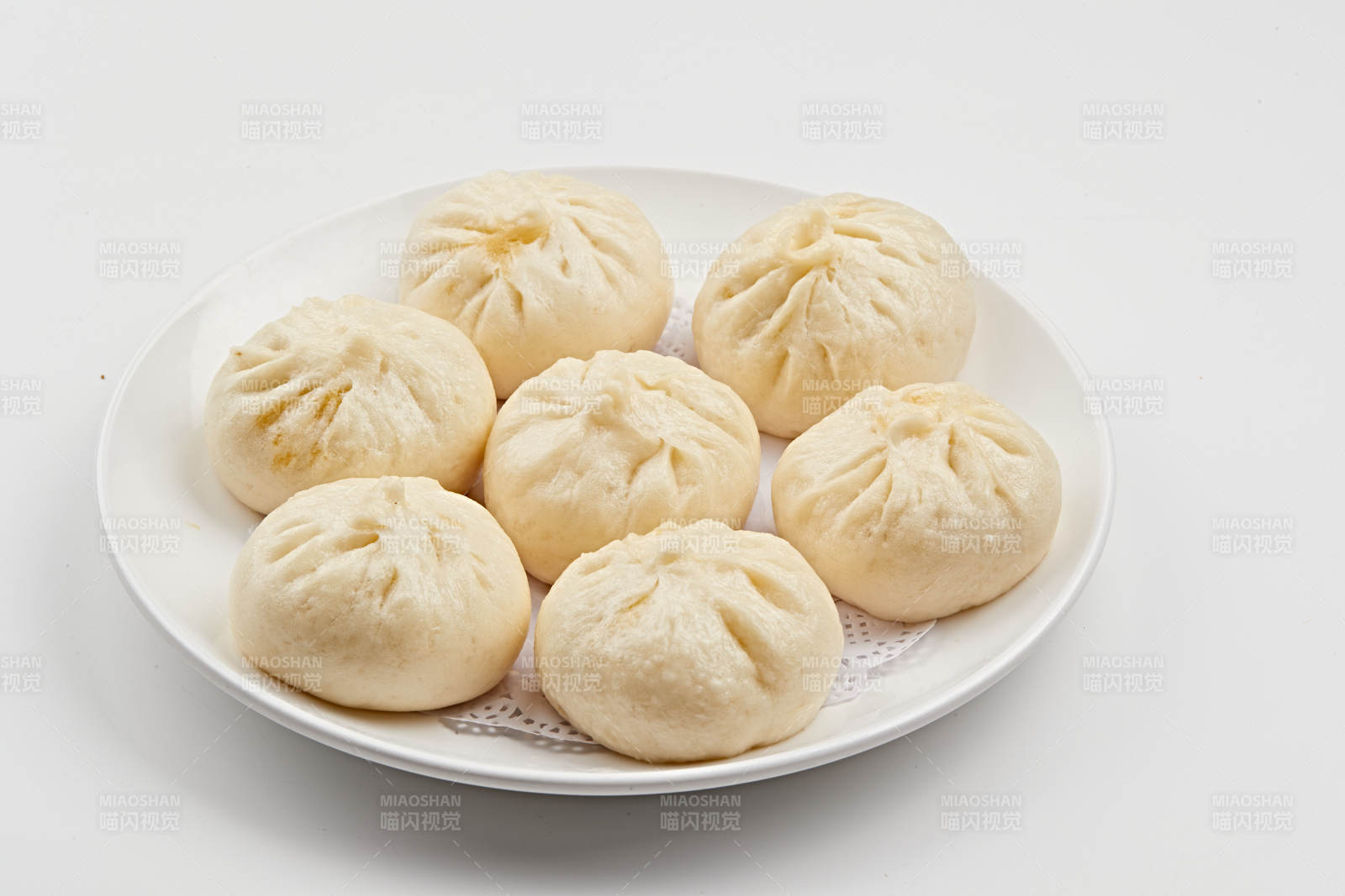 白色瓷盤裝的熏肉餡料傳統大包子