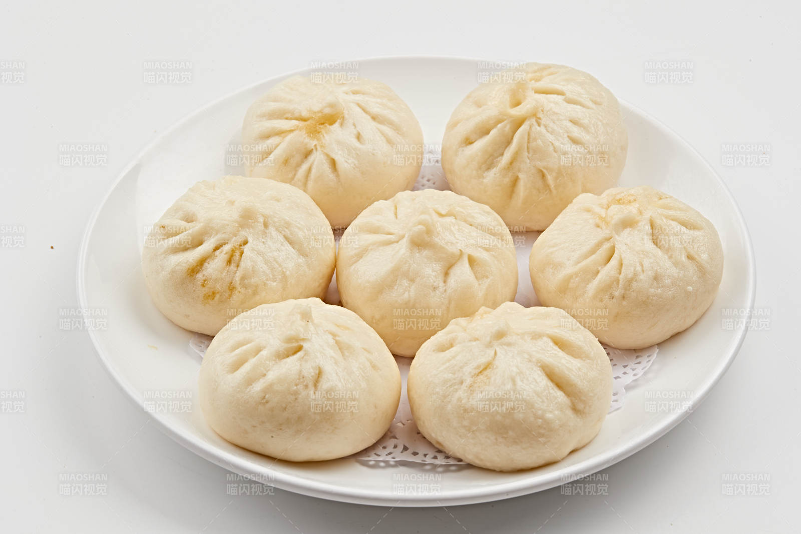 白色瓷盤裝的熏肉餡料傳統大包子