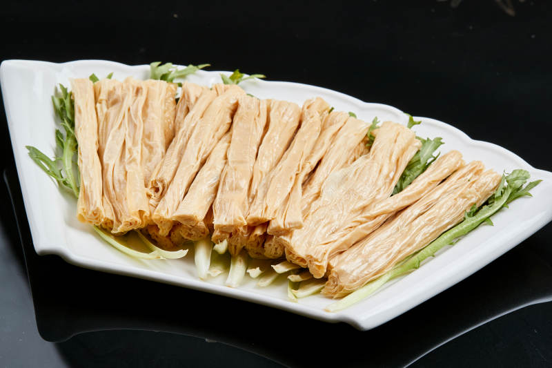 白色瓷盘装的火锅食材腐竹段