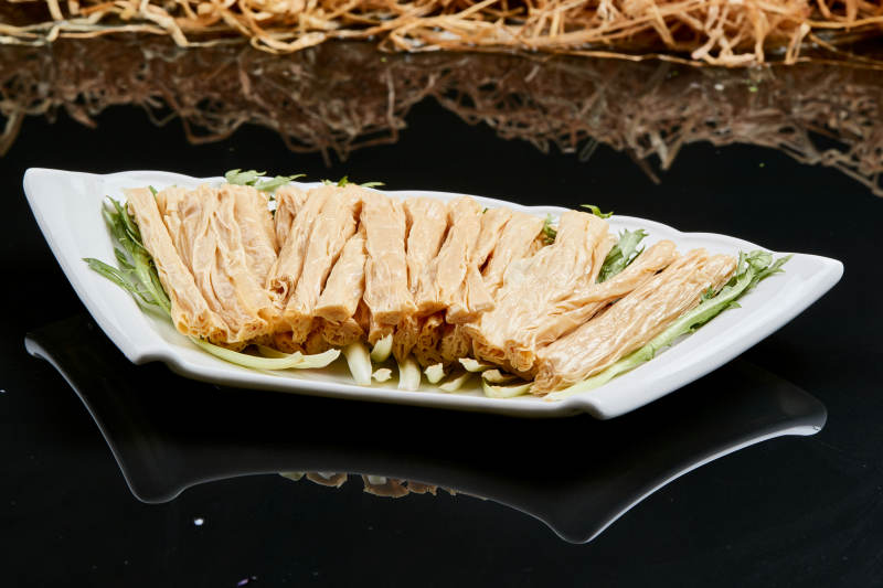 白色瓷盘装的火锅食材腐竹段