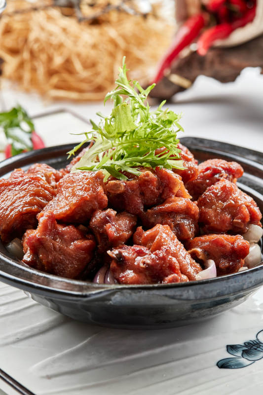 黑色砂锅装的葱香红烧鸡块