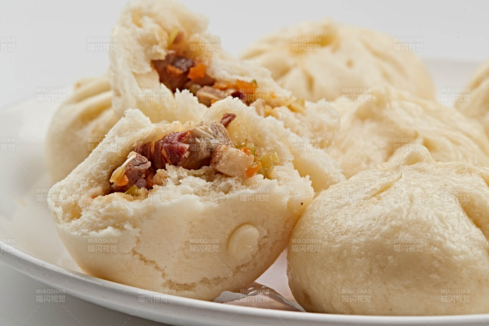 白色瓷盤裝的熏肉餡料傳統大包子