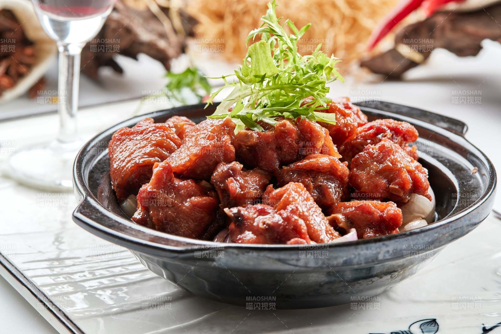 黑色砂锅装的葱香红烧鸡块