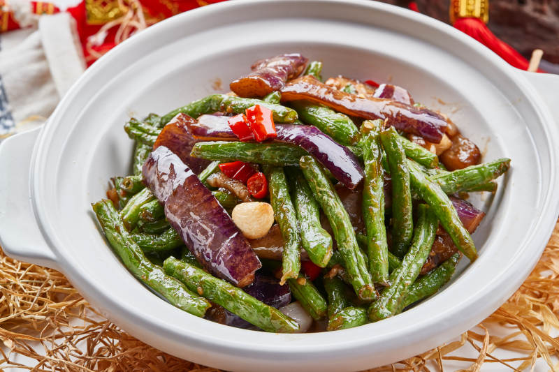 白色砂锅装的豆角茄子煲