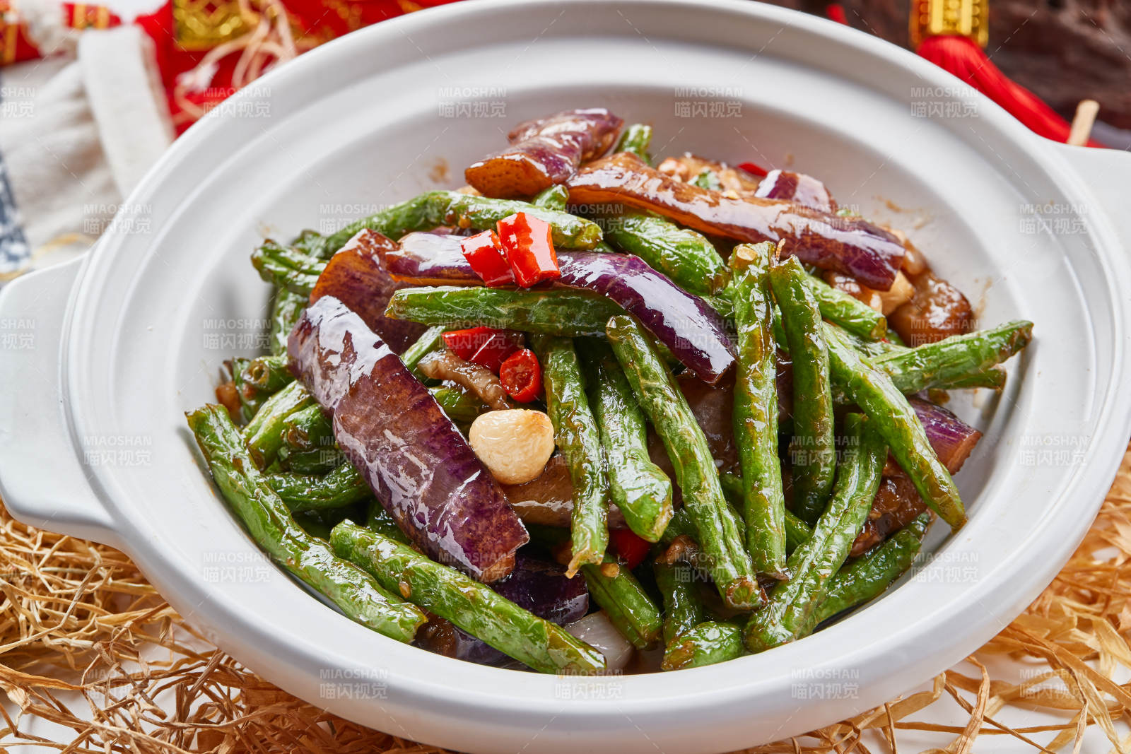 白色砂锅装的豆角茄子煲