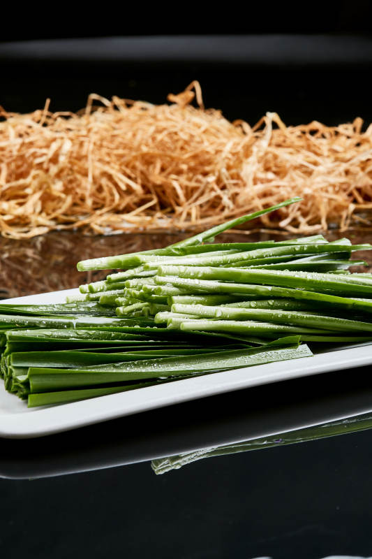 白色瓷盘装的火锅涮肉食材鲜韭菜