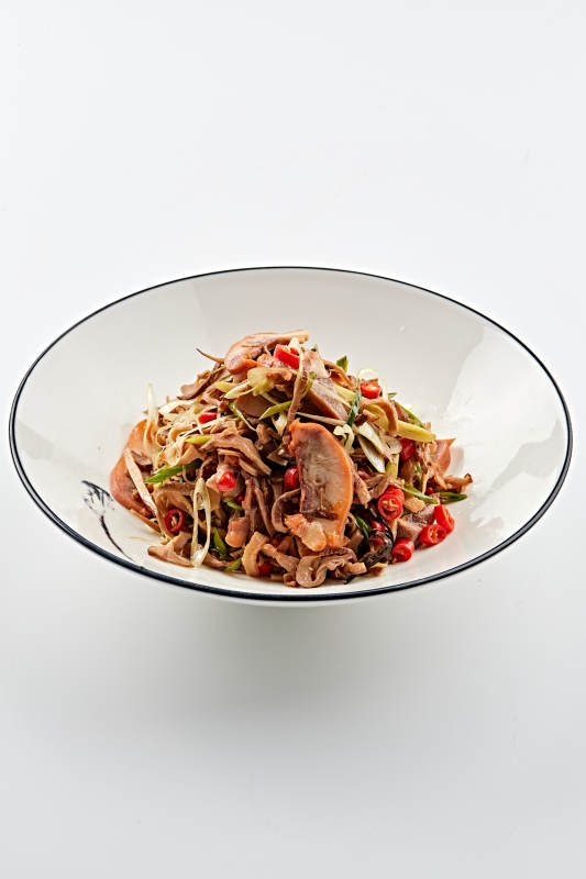 白色瓷盘装的香味小炒猪头肉