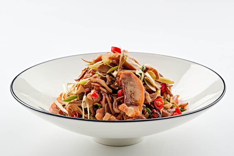 白色瓷盘装的香味小炒猪头肉