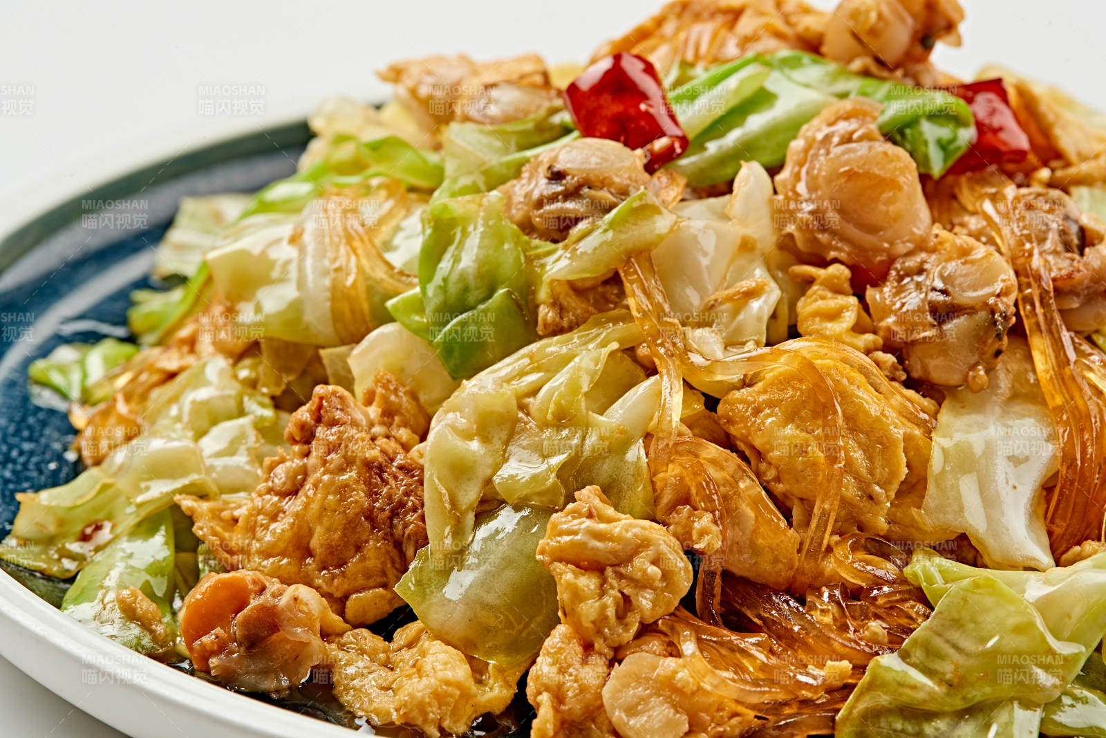 青釉瓷盤裝的扇貝丁水晶粉雞蛋爆手撕包菜