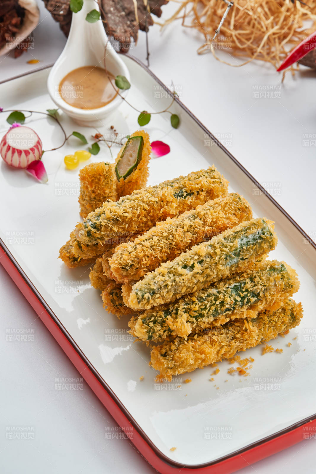 红白瓷盘装的裹面包糠油炸虾泥秋葵