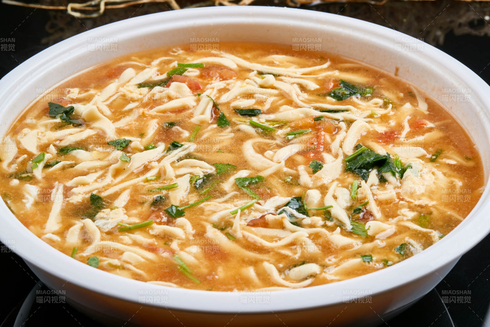 白色瓷盤裝的西紅柿雞蛋白面撥魚湯