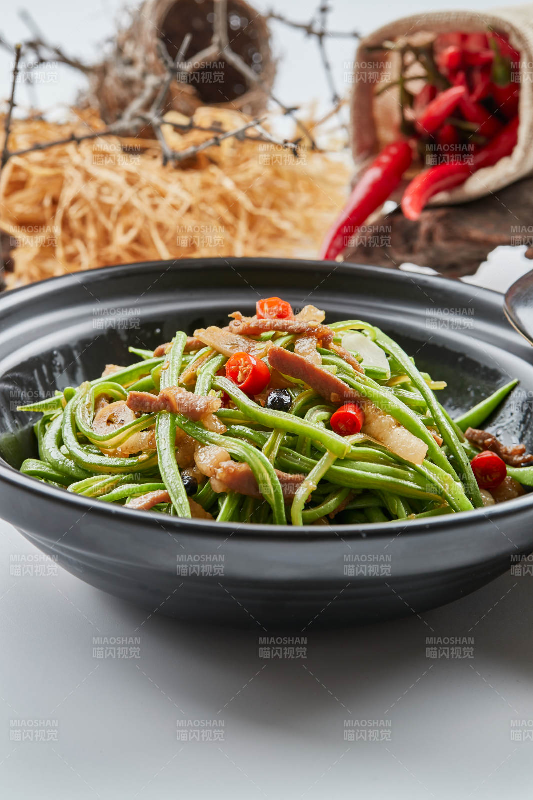 黑色砂锅装的米椒肉丝煲豇豆丝