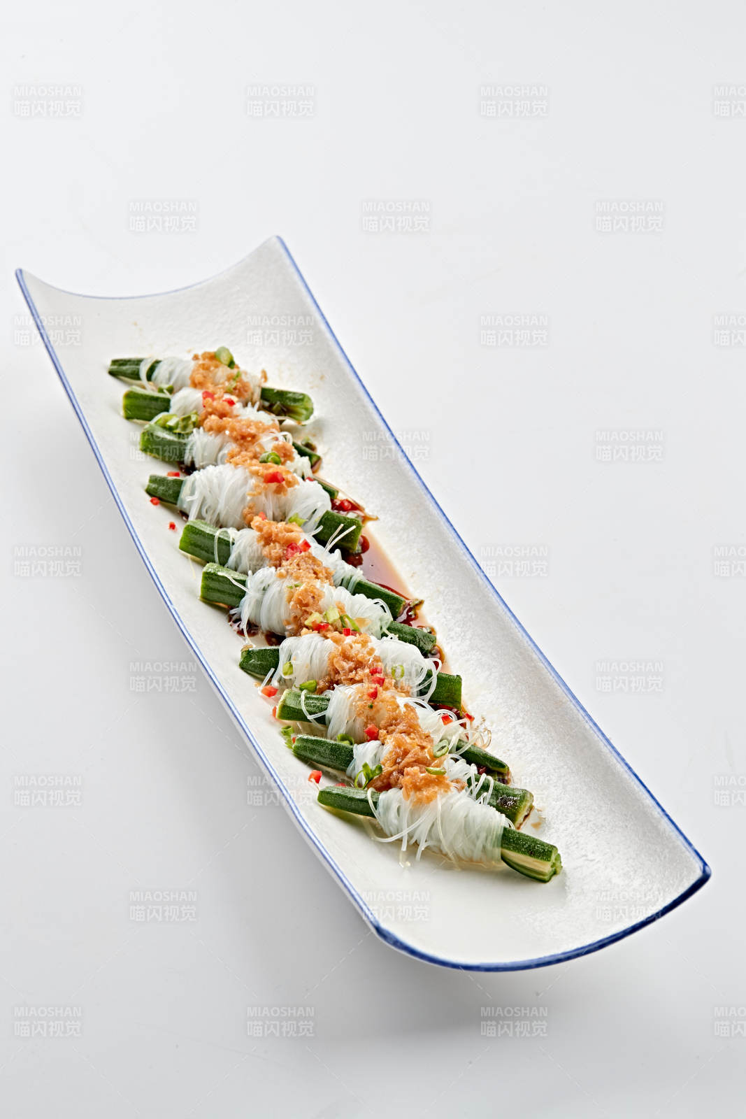 白色瓷盘装的蒜蓉粉丝蒸秋葵