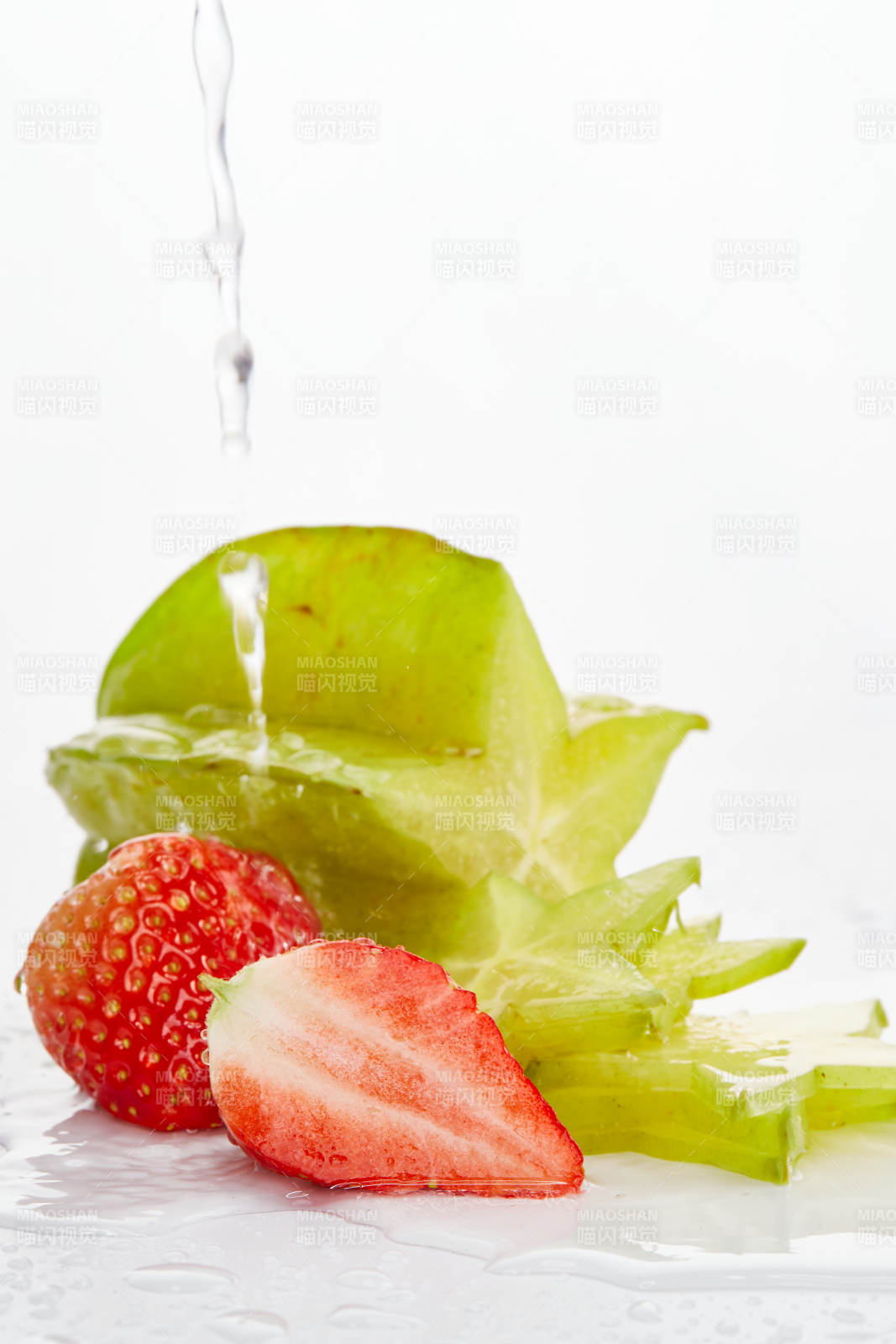 白色背景上擺放的新鮮洋桃和草莓及切片