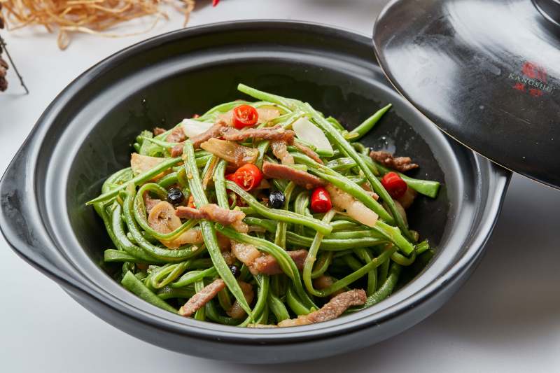 黑色砂锅装的米椒肉丝煲豇豆丝