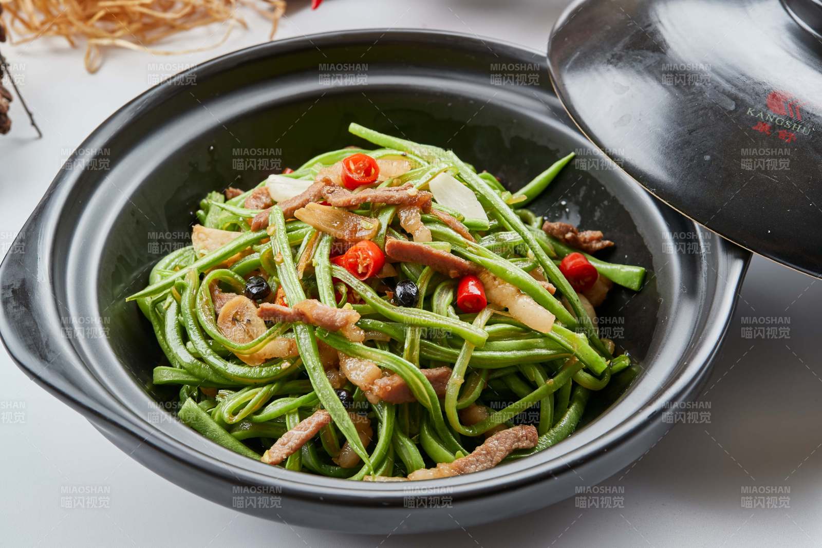 黑色砂锅装的米椒肉丝煲豇豆丝