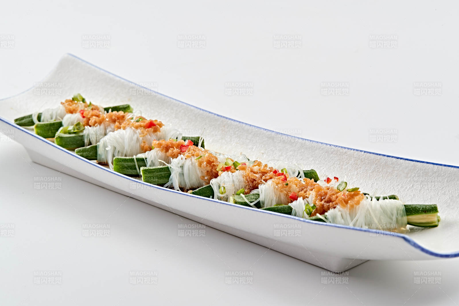 白色瓷盘装的蒜蓉粉丝蒸秋葵