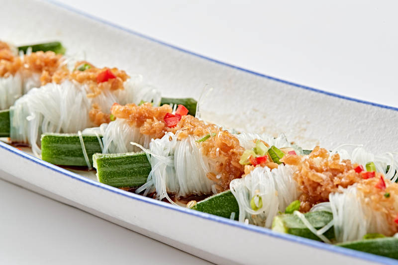 白色瓷盘装的蒜蓉粉丝蒸秋葵