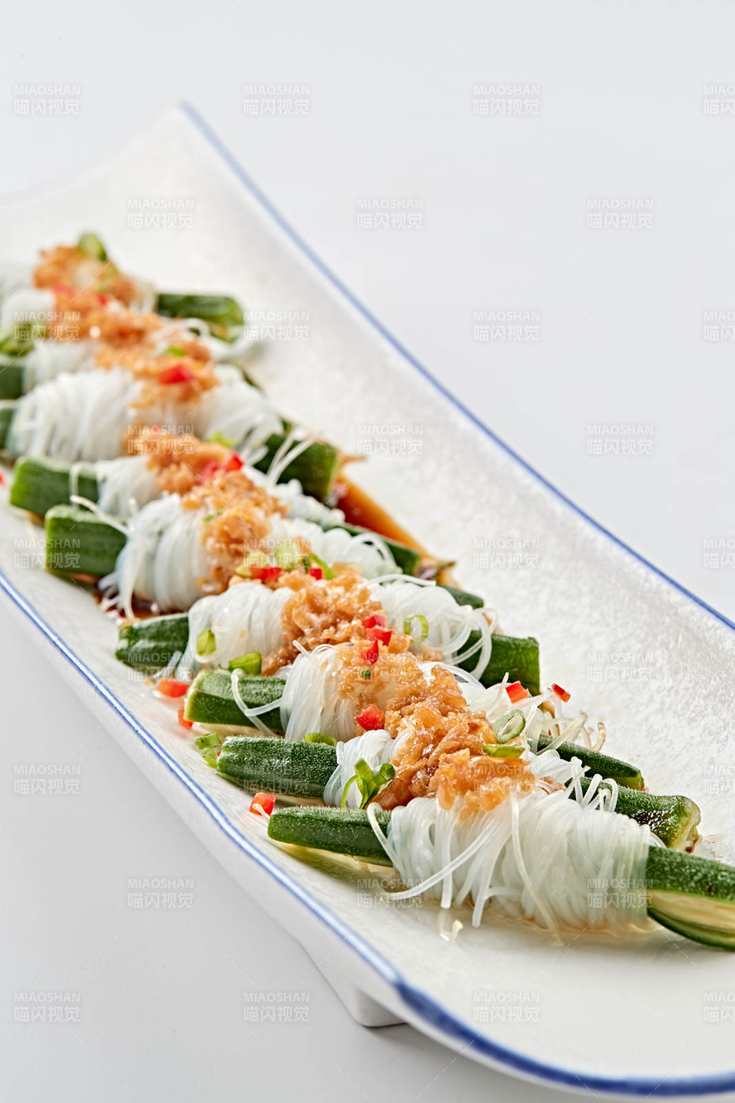 白色瓷盘装的蒜蓉粉丝蒸秋葵