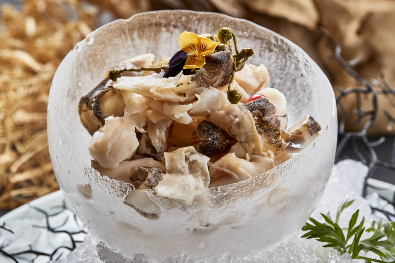 冰制作的餐具器皿裝的大海螺肉溫拌螺頭