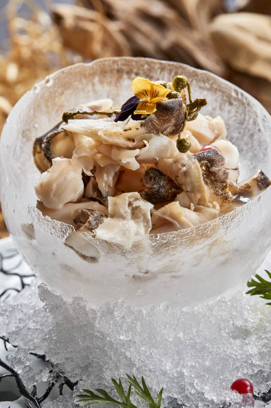 冰制作的餐具器皿裝的大海螺肉溫拌螺頭