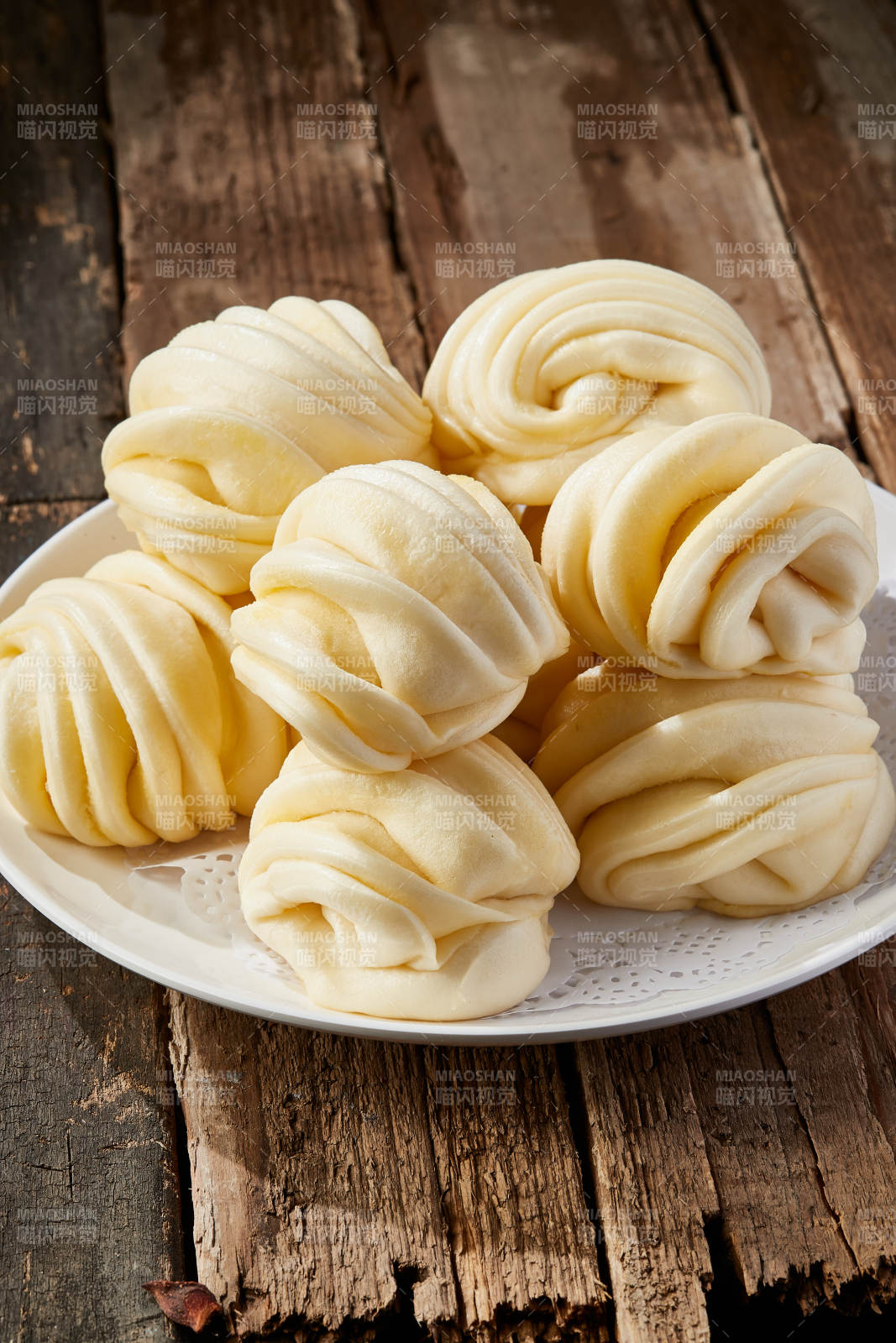白色瓷盤裝的現(xiàn)蒸麻油花卷