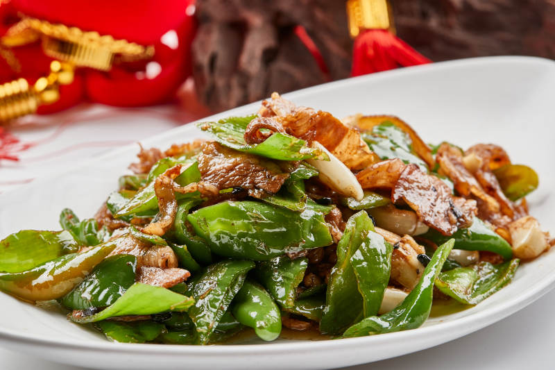 白色瓷盘装的杭椒小炒肉