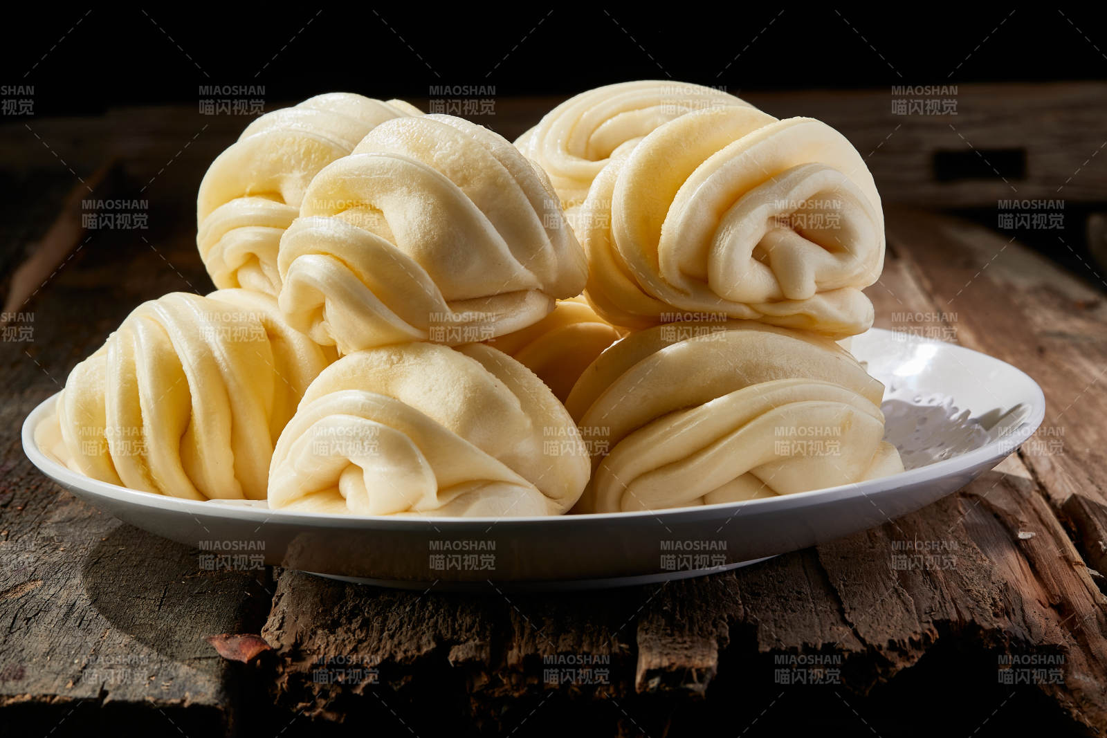 白色瓷盤裝的現蒸麻油花卷