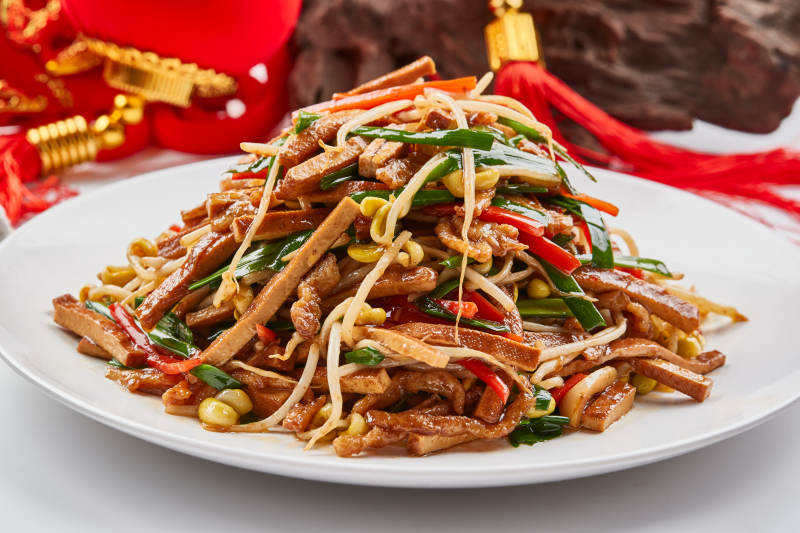 白色瓷盘装的彩椒丝黄豆芽拌香干