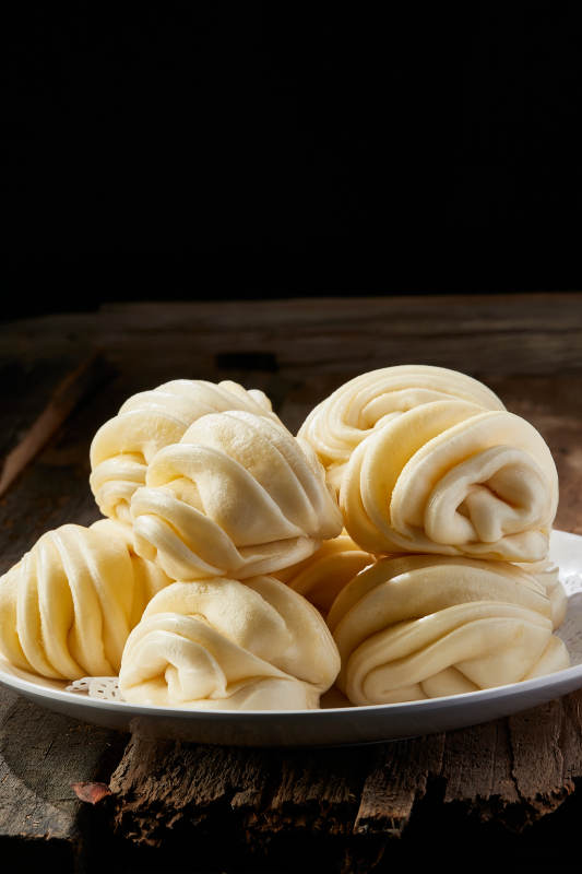 白色瓷盘装的现蒸麻油花卷