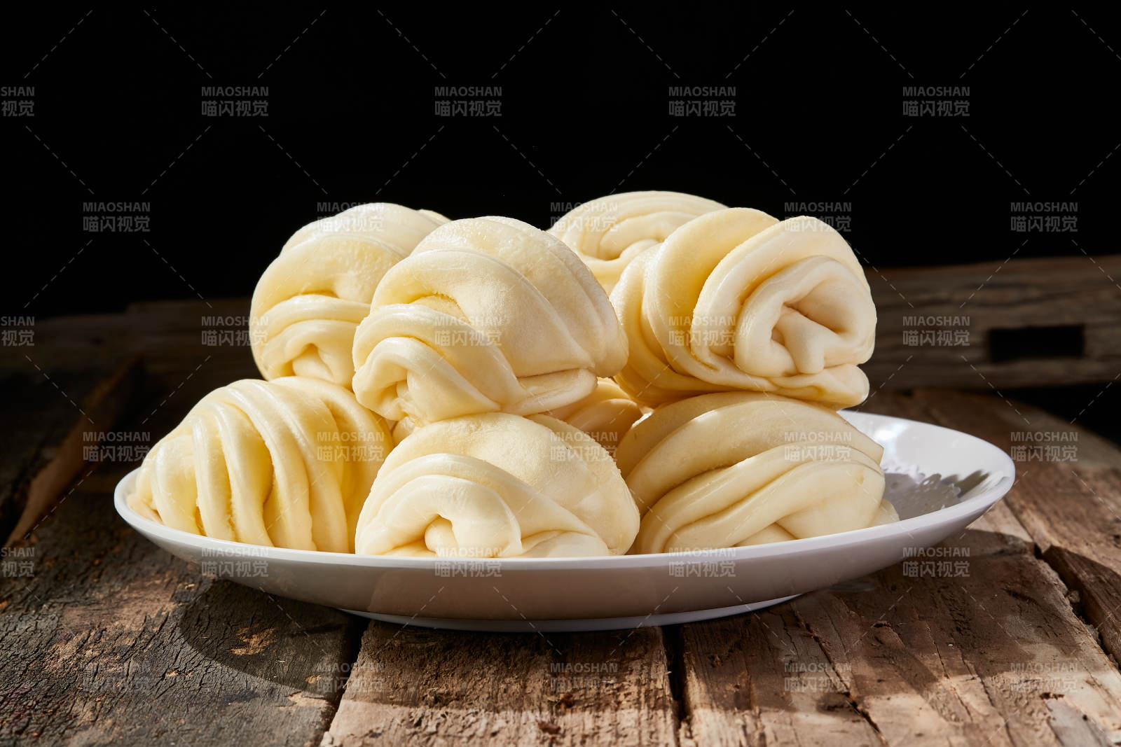 白色瓷盘装的现蒸麻油花卷