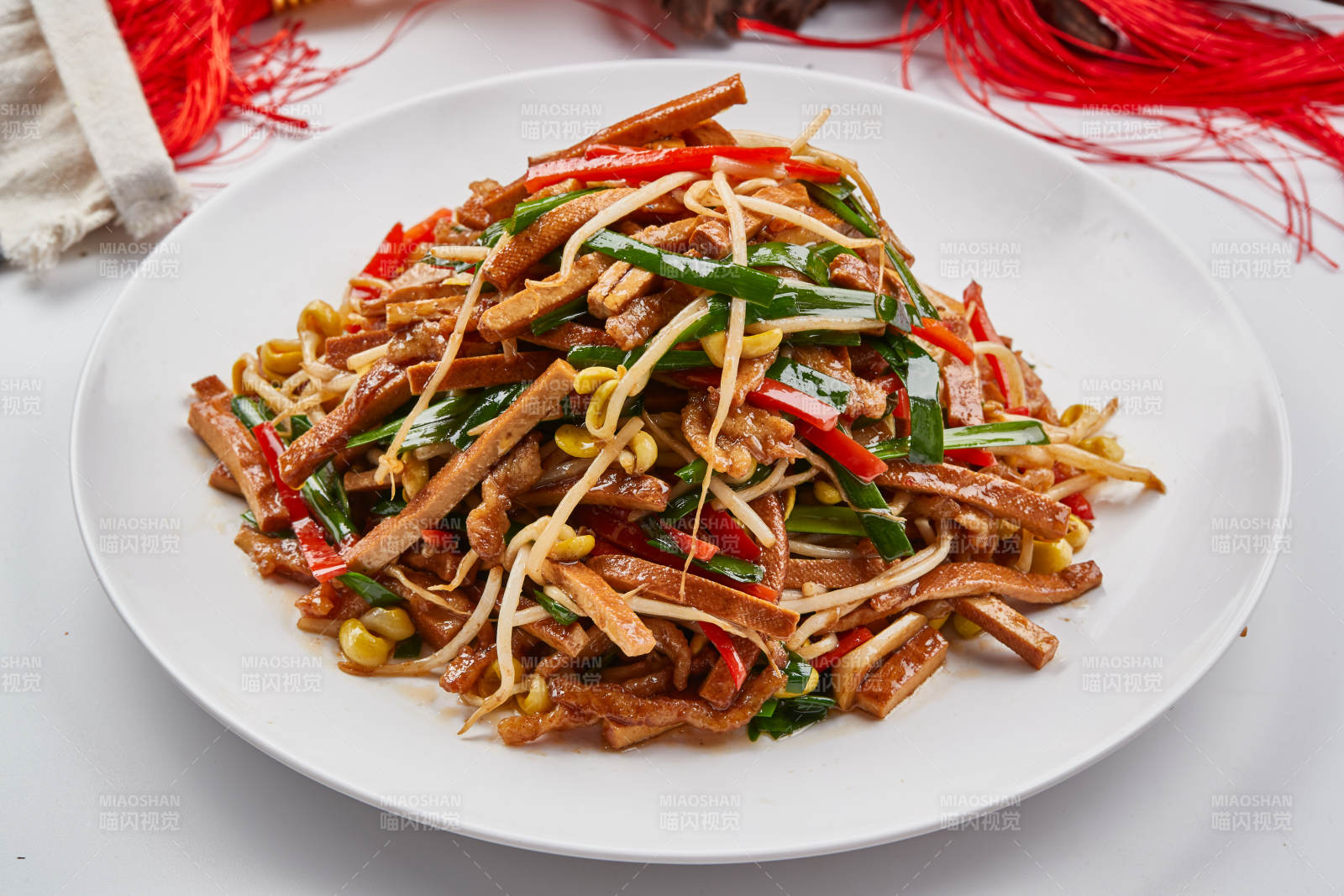 白色瓷盘装的彩椒丝黄豆芽拌香干