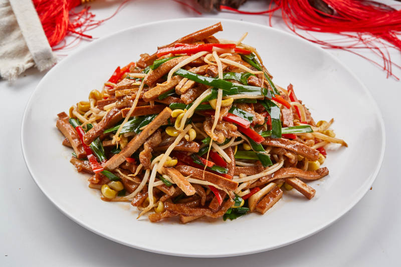 白色瓷盘装的彩椒丝黄豆芽拌香干