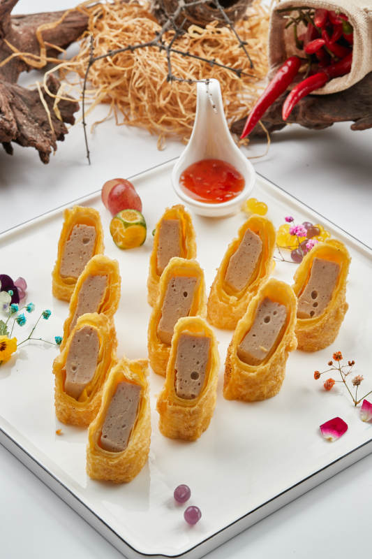 白色瓷盘装的蘸酱虾泥蛋卷