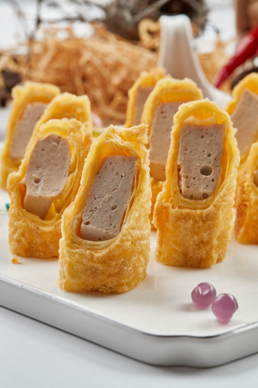 白色瓷盘装的蘸酱虾泥蛋卷