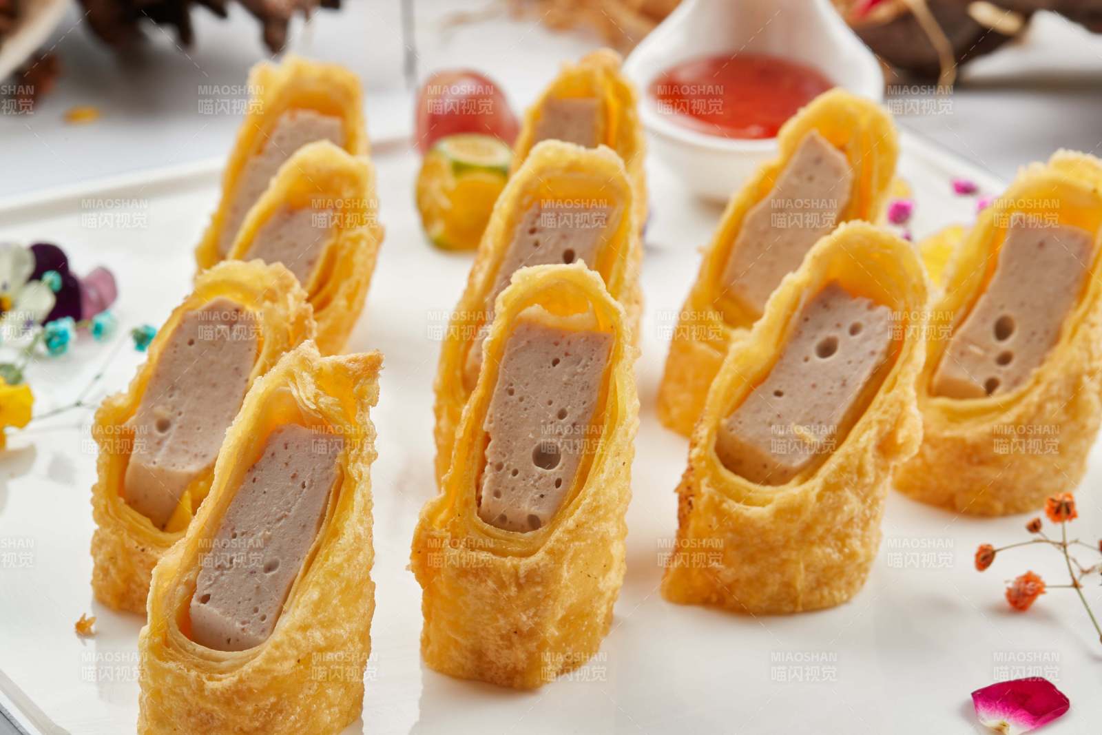 白色瓷盤裝的蘸醬蝦泥蛋卷