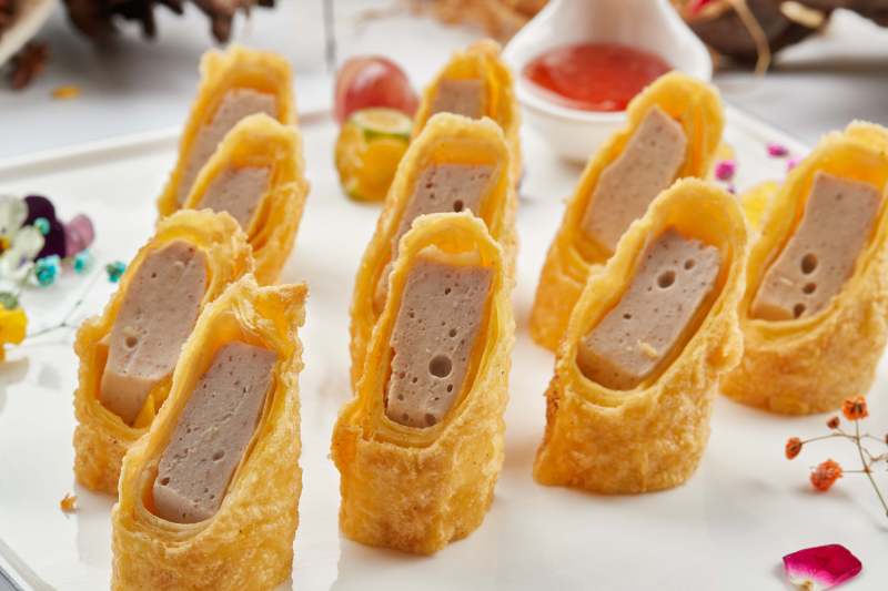 白色瓷盘装的蘸酱虾泥蛋卷