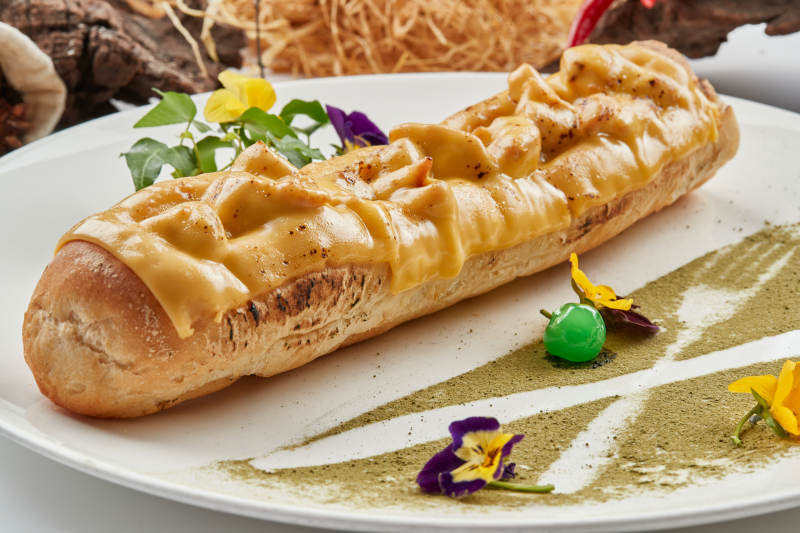 白色瓷盘装的的芝士火腿焗法棍面包