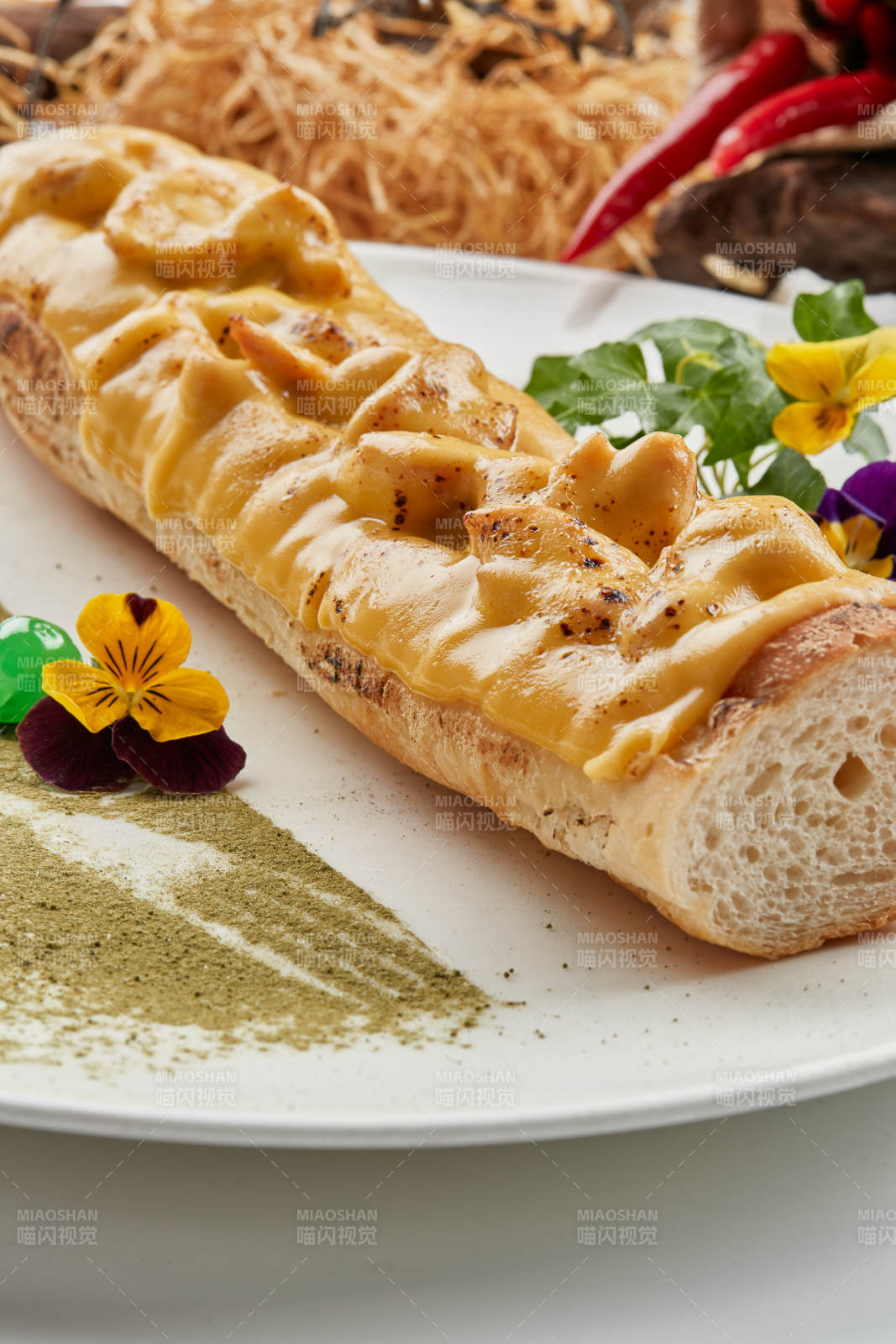 白色瓷盘装的的芝士火腿焗法棍面包