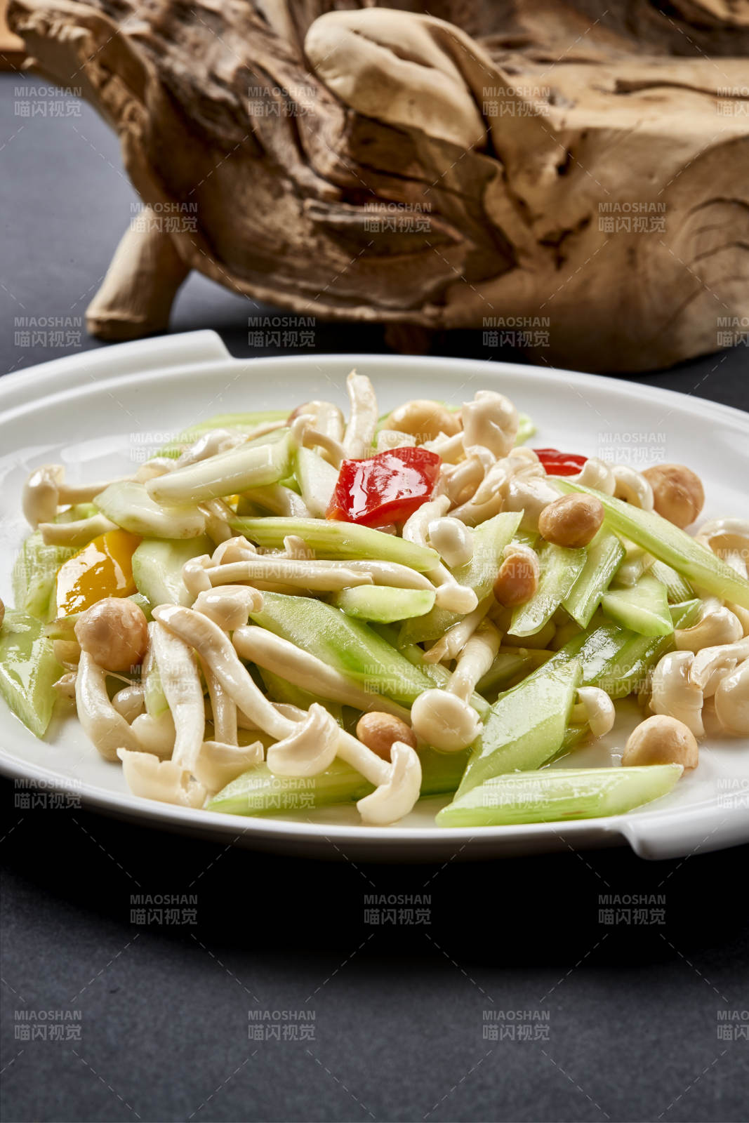 圆瓷盘装的西芹彩椒小炒白玉菇