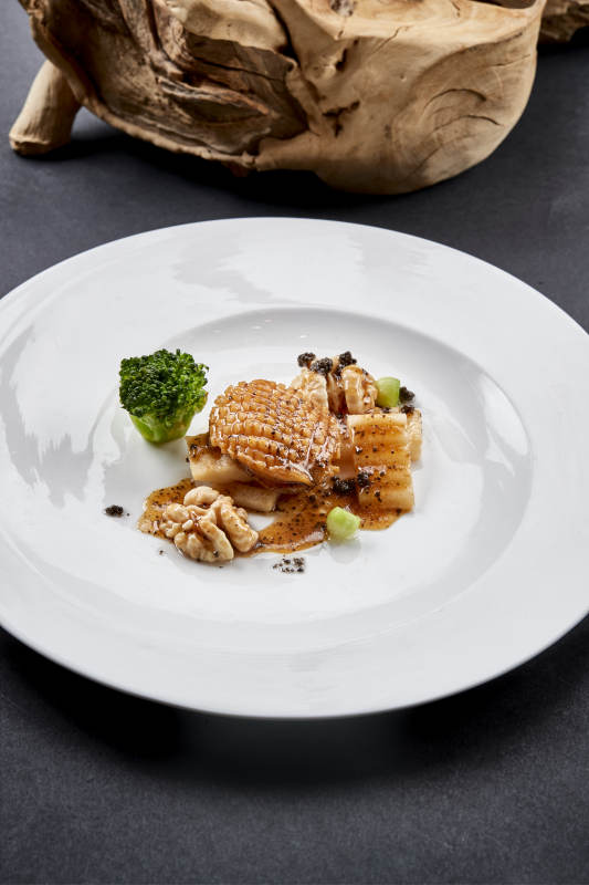 白色圆瓷盘装的黑胡椒桃仁大连鲍