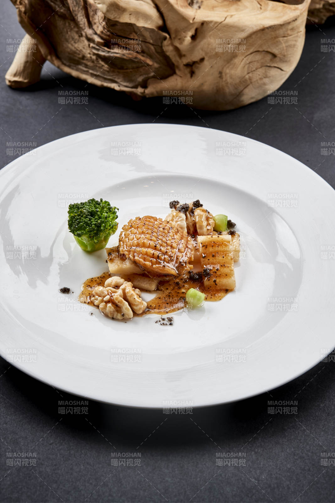 白色圆瓷盘装的黑胡椒桃仁大连鲍