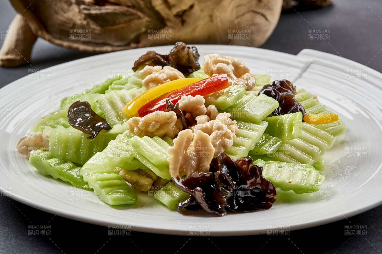 圓瓷盤裝的乳瓜桃仁彩椒炒木耳