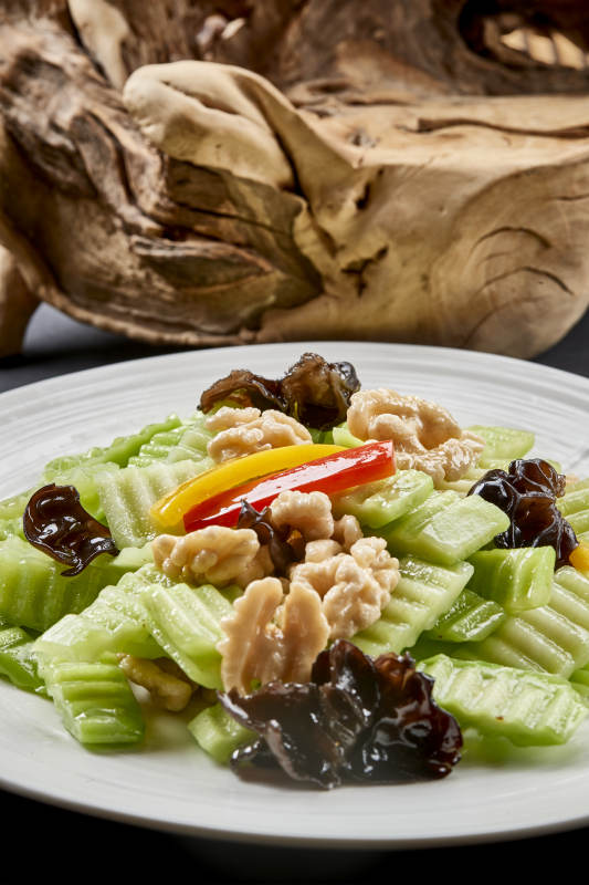 圓瓷盤裝的乳瓜桃仁彩椒炒木耳